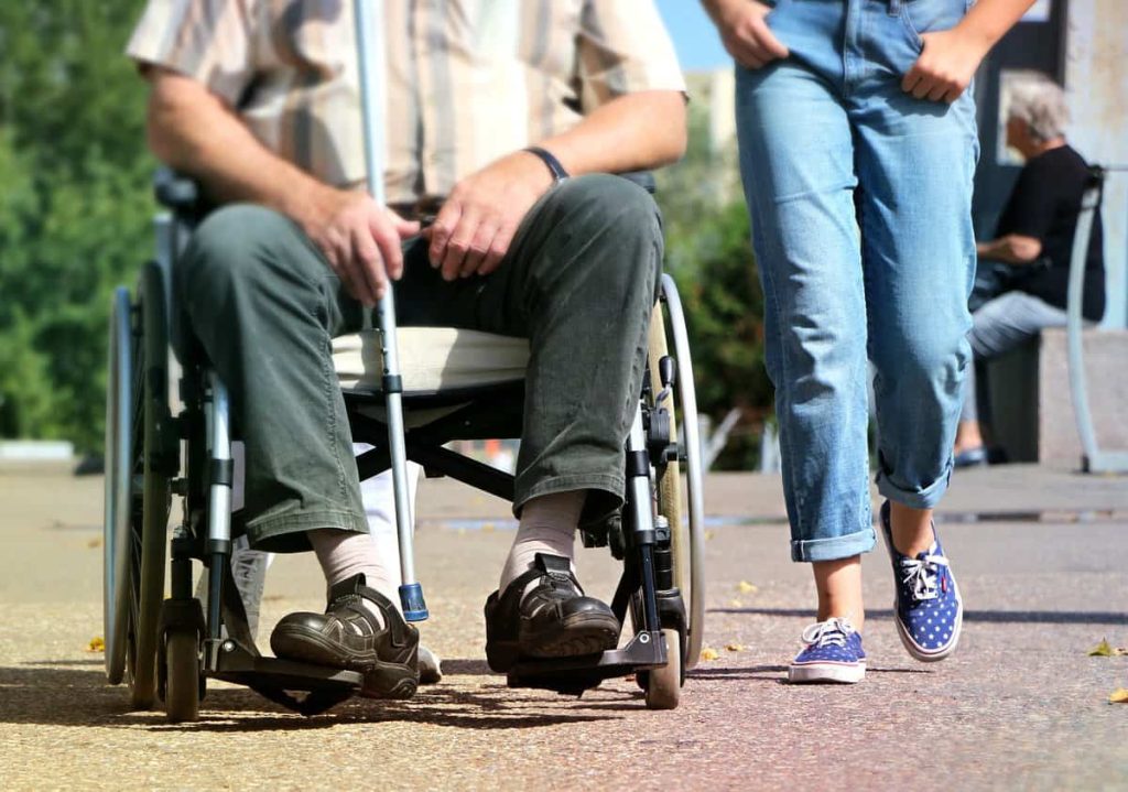 a disabled man being assisted by a woman.