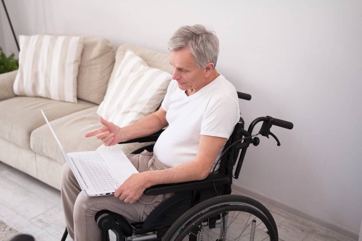 Disabled person in wheelchair working on laptop